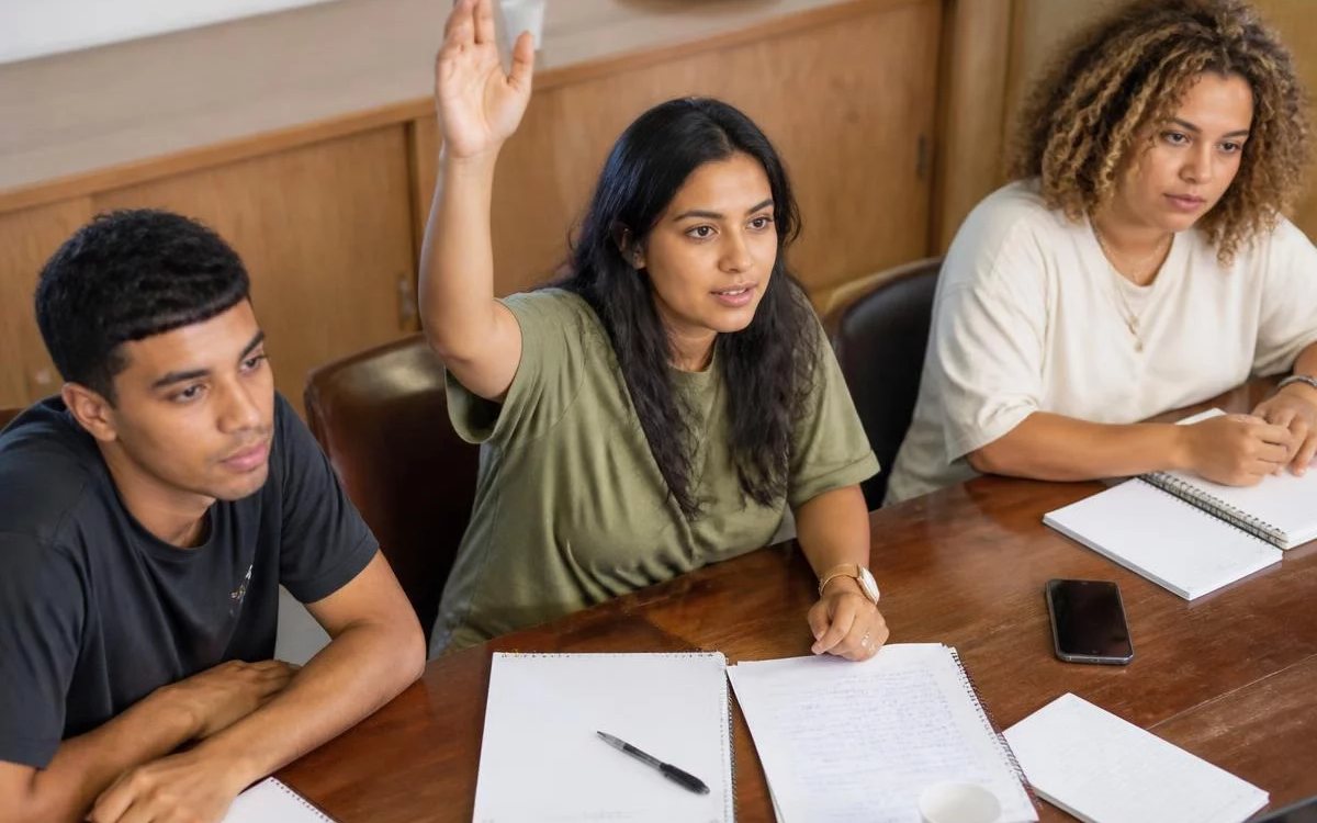 Grupo pequeno reunido em volta da mesa, ouvindo a fala de quem tem a palavra